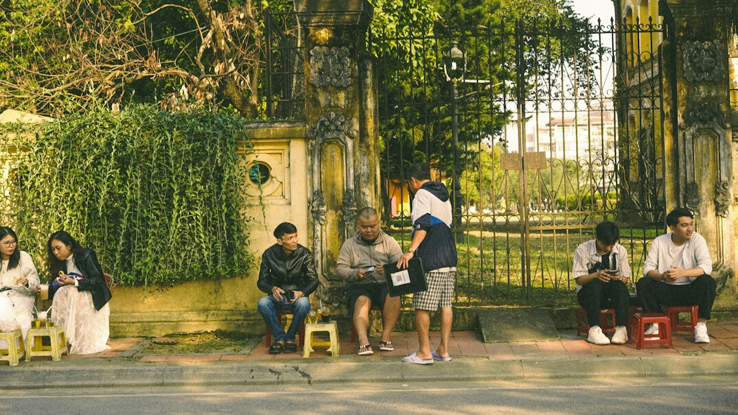 Group of students sitting together outdoors with notebooks
