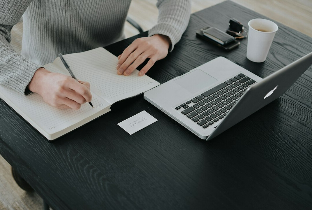 person setting goals in notebook